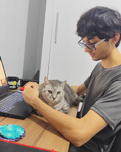Vinícius working with his cat